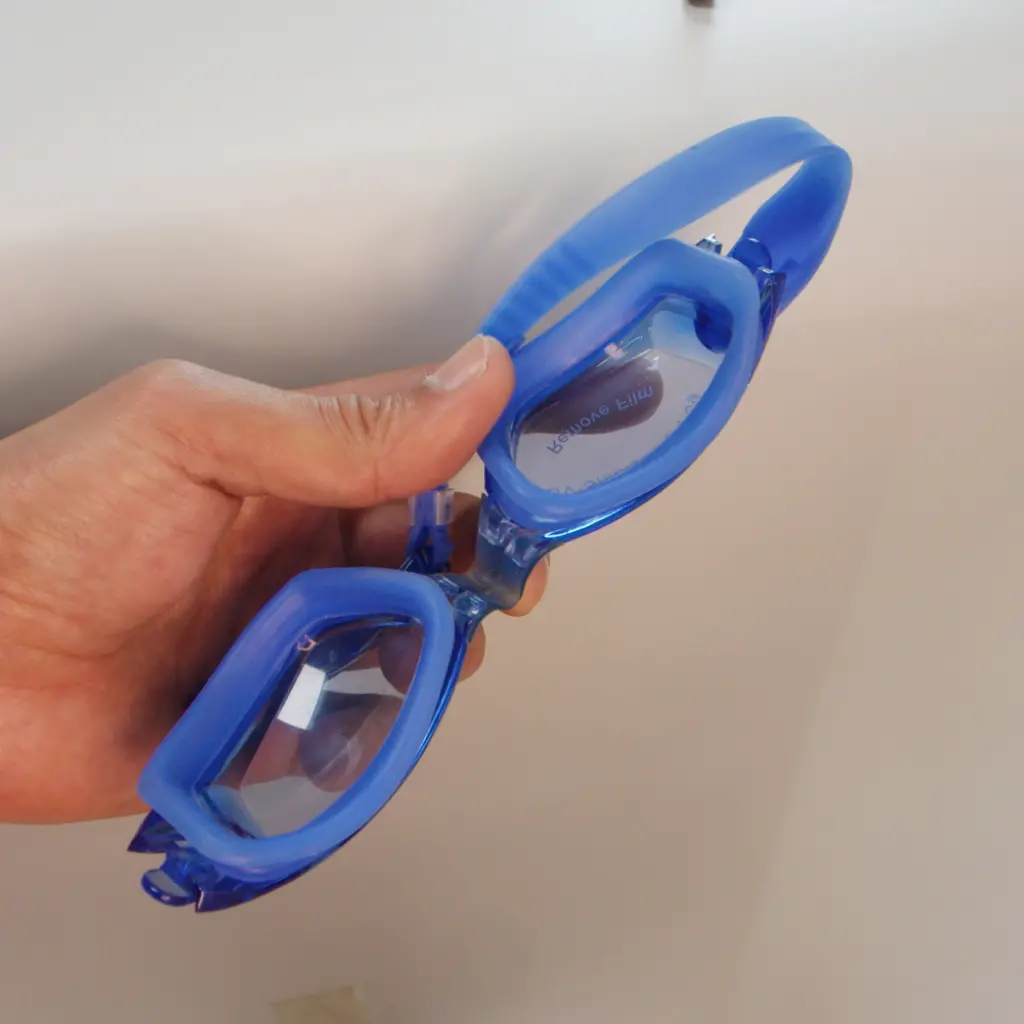 Blue silicone overmolded onto plastic swimming goggle frame for facial seal