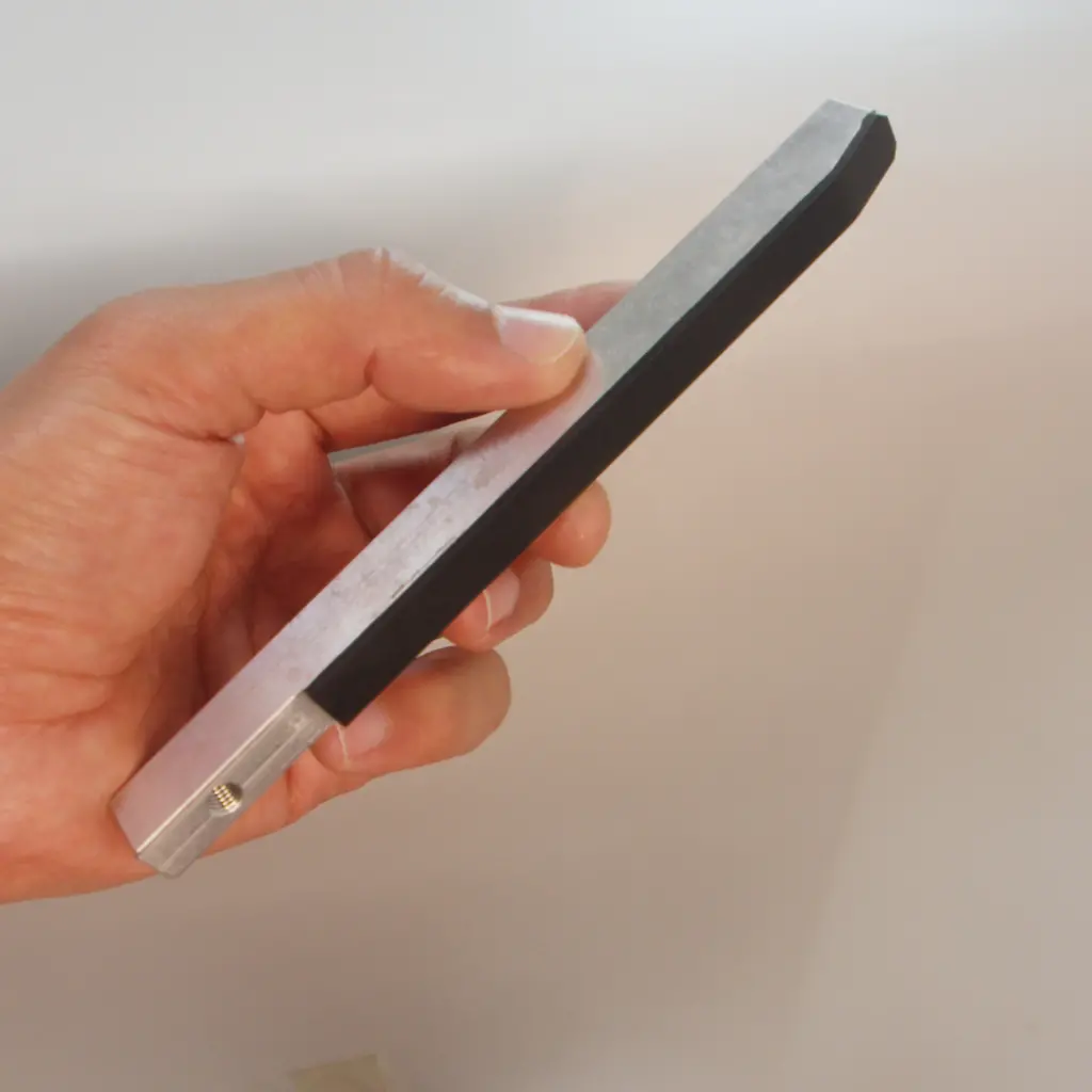 Black silicone overmolded along the edge of an aluminium flat bar