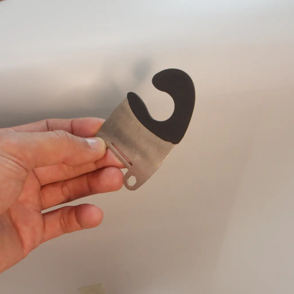 Black rubber overmolded onto stainless steel spatula clip for grip and heat resistance