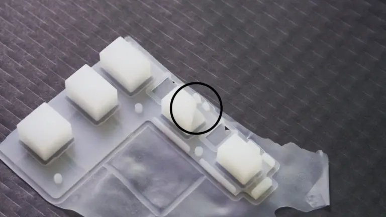 Image of an incomplete silicone keyboard product with missing details and sections, indicating insufficient pressure during the molding process.