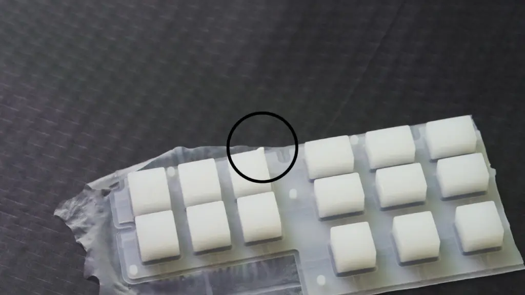 Image of a defective silicone product with uneven surface and gaps, caused by too low compression temperature, resembling a keyboard bubble.